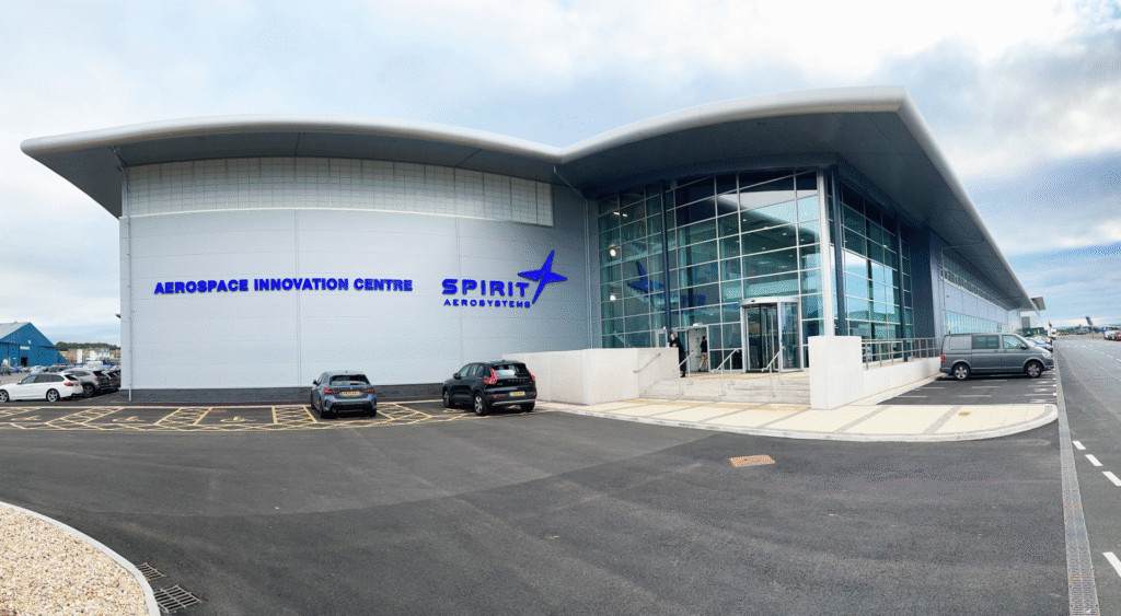 Außenansicht eines modernen Firmengebäudes mit der Aufschrift „Aerospace Innovation Centre“ und „Spirit AeroSystems“