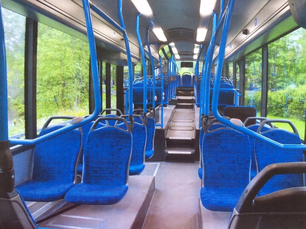 Innenansicht eines leeren Busses mit blauen Sitzen und Blick nach vorn durch die Mittelgangzone.