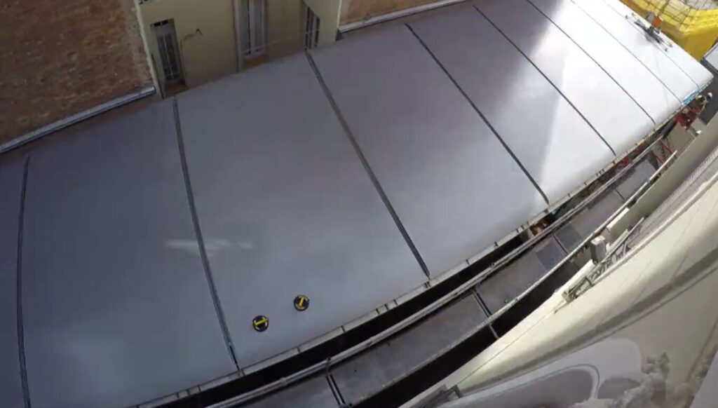 Blick auf ein großes graues Stoff- oder Dachsegment zwischen Gebäuden