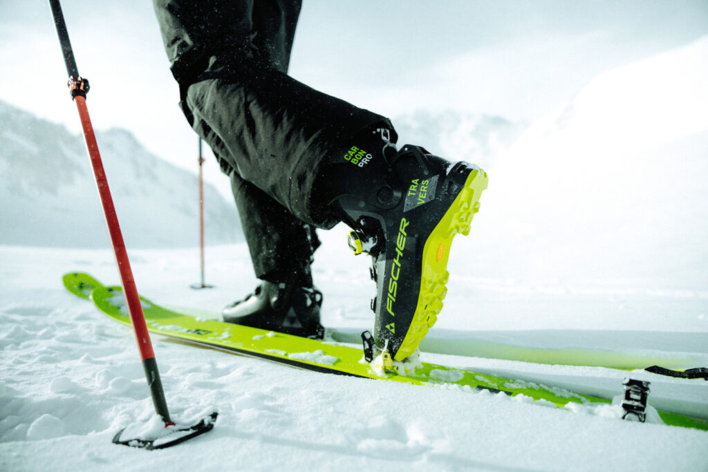A skier stands on green skis in the snow.