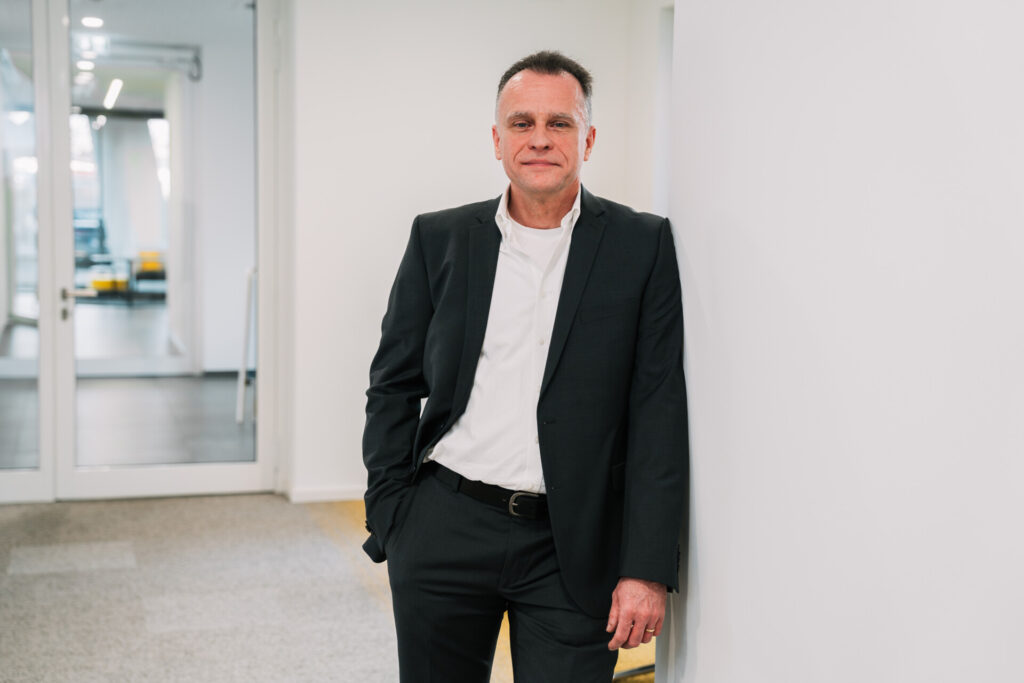 Man in suit leaning against a wall