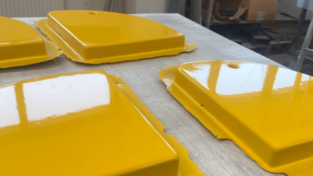 Four yellow painted molds on a workbench