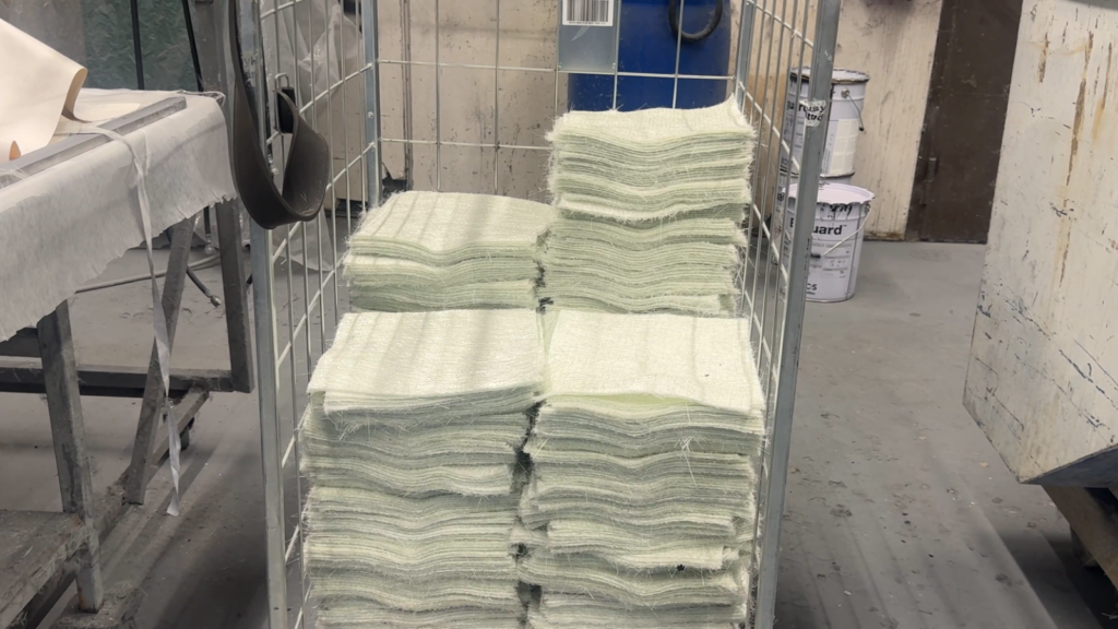 Stack of cut whitish layers of fabric in a trolley